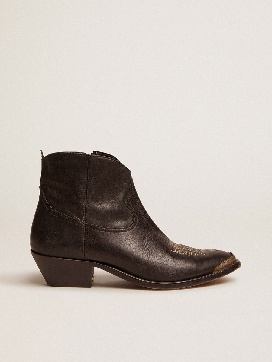 unga ankelboots i svart läder med sandfärgad broderi