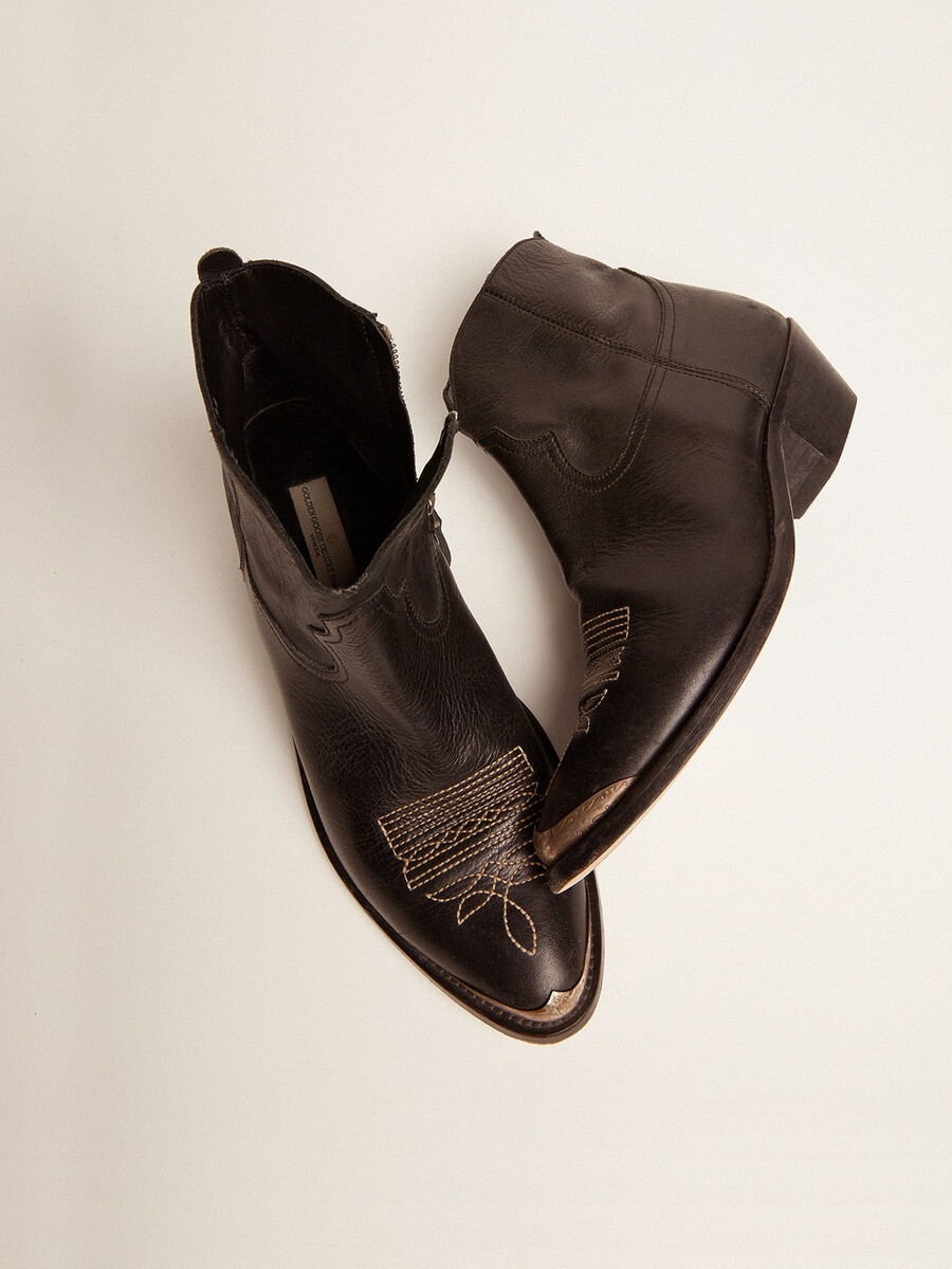 unga ankelboots i svart läder med sandfärgad broderi