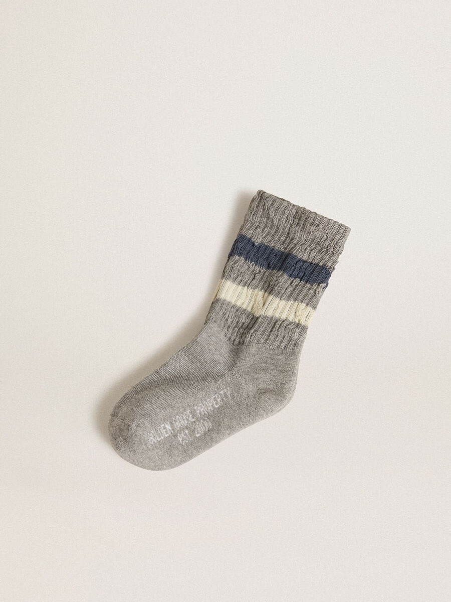 barns grå strumpor med slitna detaljer och slitna vita och blå ränder