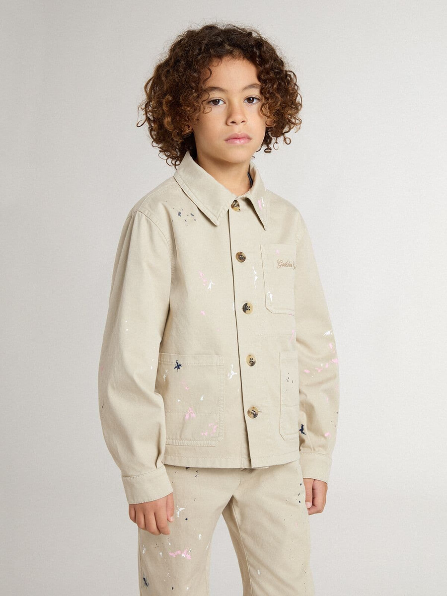beige barnjacka med flerfärgade stänk