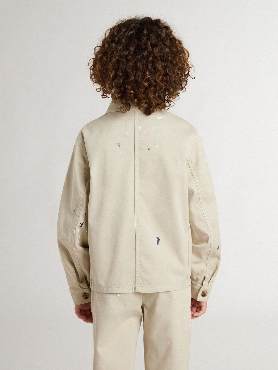 beige barnjacka med flerfärgade stänk