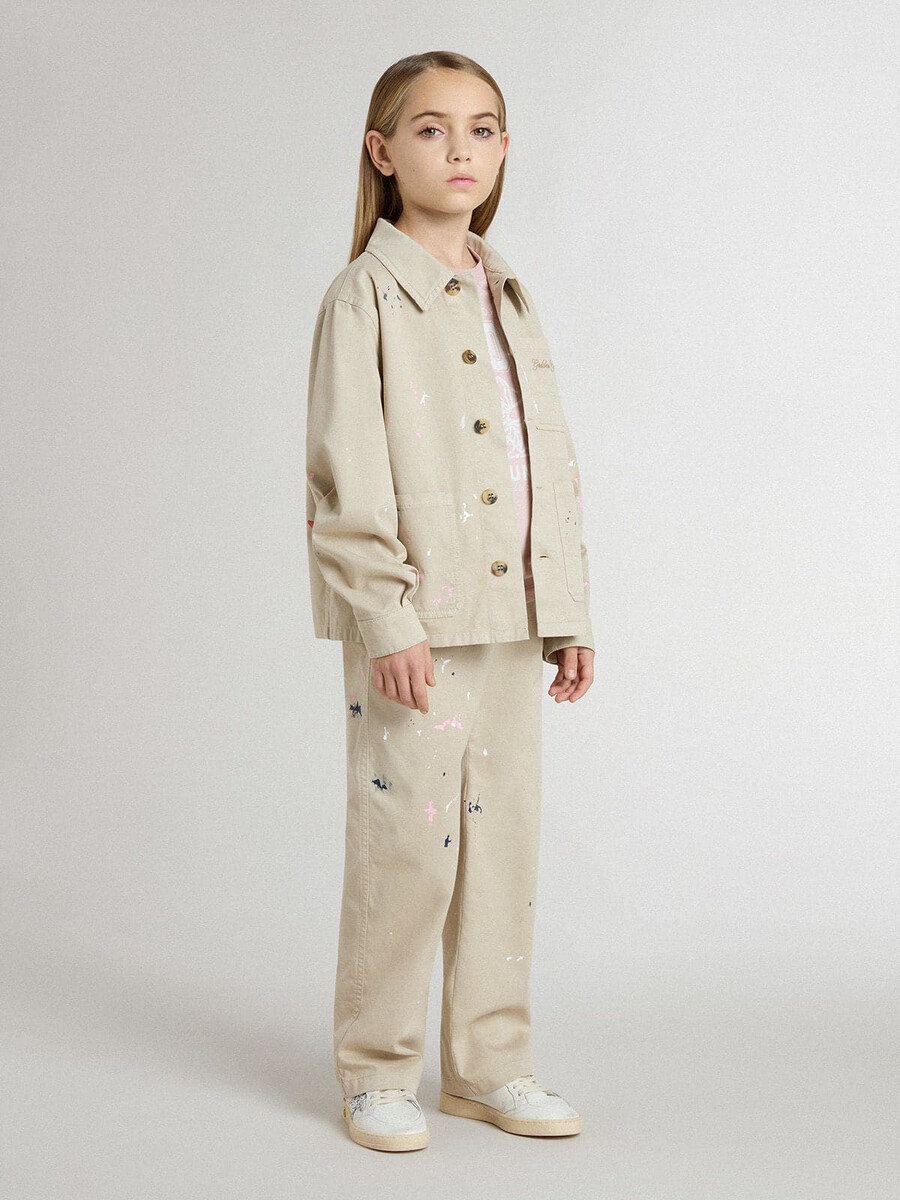beige barnjacka med flerfärgade stänk