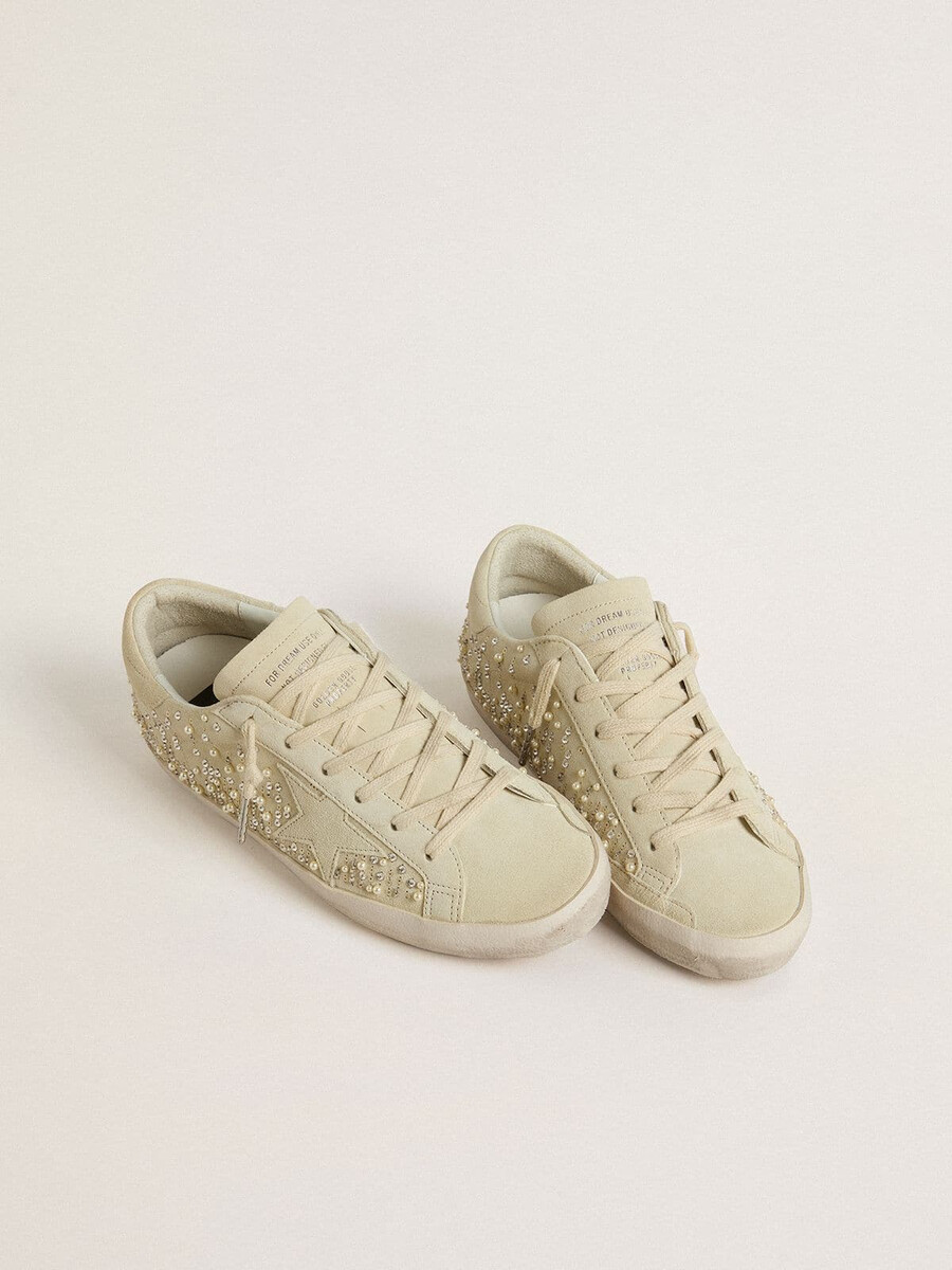 dam super-star i beige mocka med pärlor och swarovski-kristaller