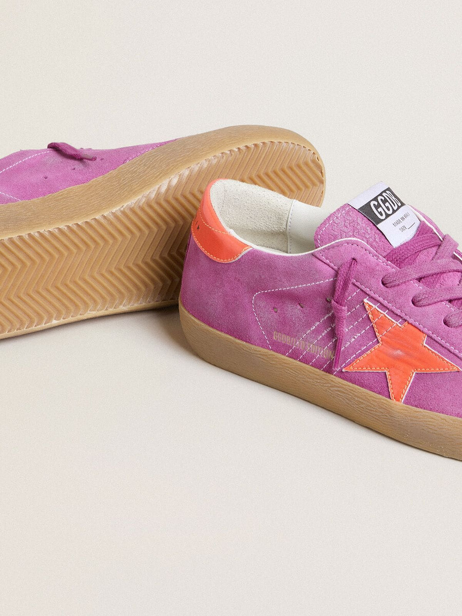 dam super-star i fuchsia mocka med fluorescerande orange laminerad läderstjärna och hälflik